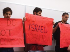 Students hold up anti-Israeli signs in protest as part of the walk-out.