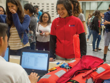 Freshmen line up at the tables to receive free hoodies.