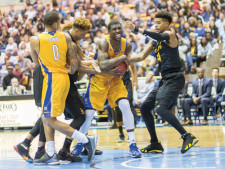 Taylor Johns (No. 5) hides the ball from his defenders.