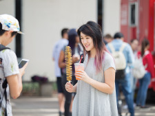 A student poses with her tornado potato stick and beverage.