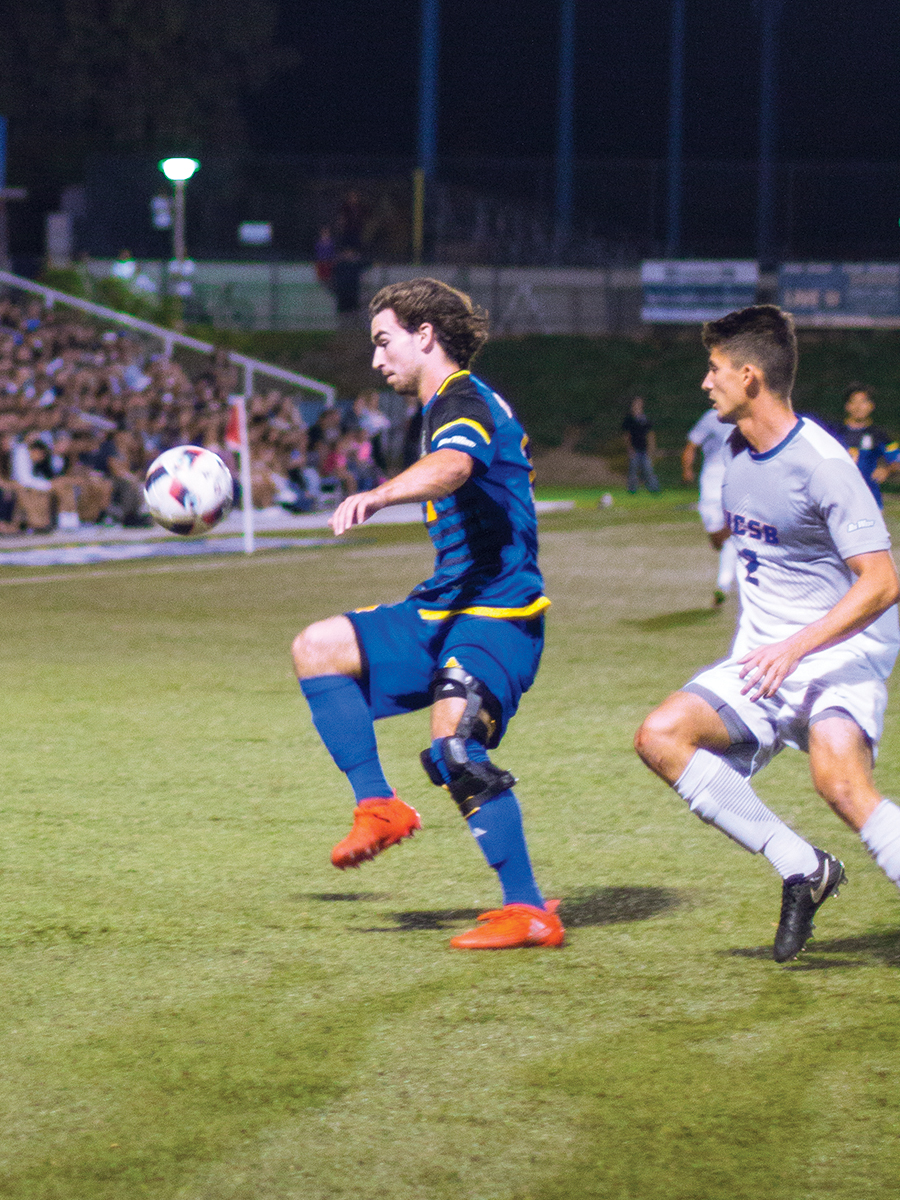 Dylan Smith (no. 14) keeps the ball away from his defender.