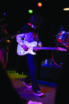Frontman Tyler Yaish checks the setlist as the band finishes a song